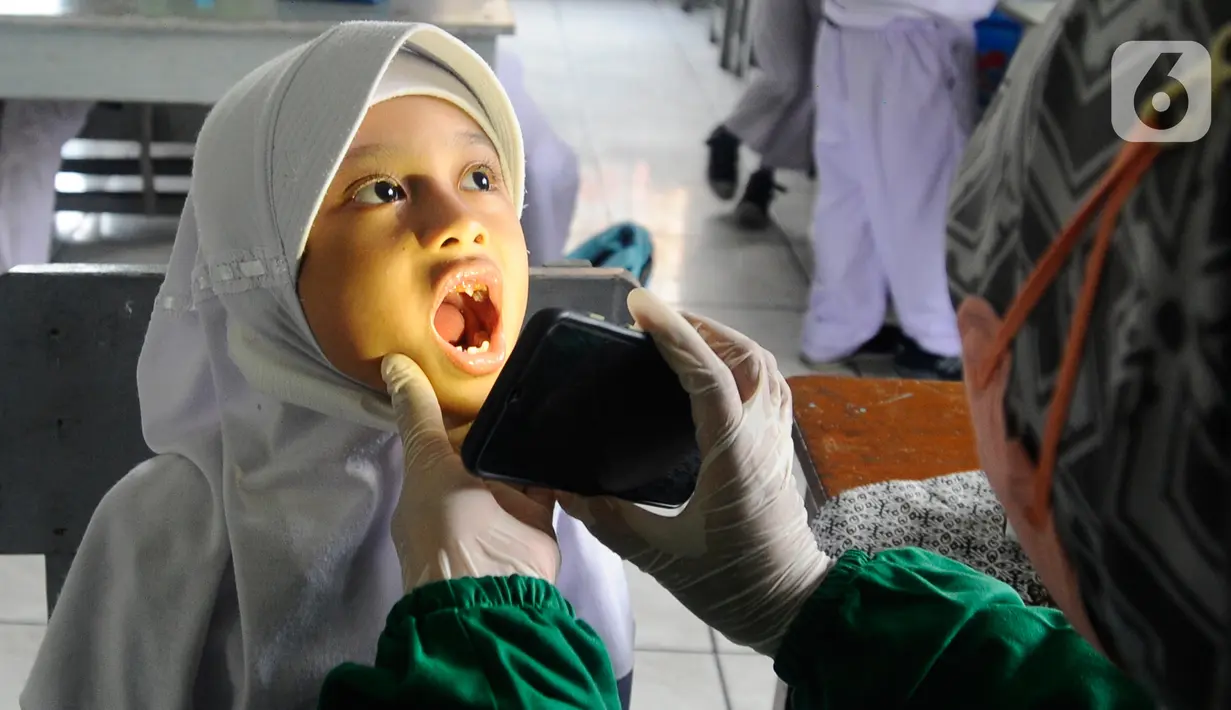 Paramedis Puskesmas Cinere memeriksa kesehatan gigi murid kelas III di SDI Al Hidayah, Cinere, depok, Senin (12/9/20222). Selain pemeriksaan gigi, telinga, dan kuku yang dilakukan periodik 6 bulan sekali  juga dilakukan penyuluhan kesehatan dan pemberian obat cacing kepada anak-anak. (merdeka.com/Arie Basuki)