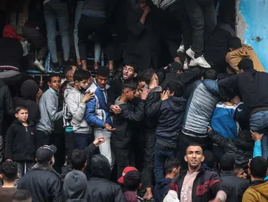 Warga Palestina berkerumun di depan sebuah toko roti untuk membeli roti di Rafah di Jalur Gaza selatan pada 15 Februari 2024. (MOHAMMED ABED/AFP)