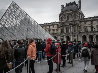 Pengunjung mengantre di luar Pyramid, pintu masuk utama menuju museum Louvre, di Paris, Rabu (4/3/2020). Louvre di Paris, museum yang paling banyak dikunjungi di dunia, kembali dibuka setelah pegawai yang khawatir dengan penularan virus corona setuju kembali masuk kerja. (Philippe LOPEZ/AFP)