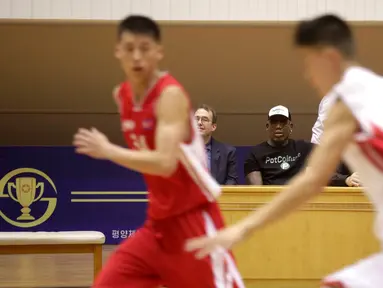 Mantan bintang basket NBA Dennis Rodman (tengah) duduk bersama Joseph Terwilliger, Academic at Columbia University, menyaksikan pertandingan tim basket Korea Utara di Pyongyang, Korea Utara (15/6). (AP Photo/Kim Kwang Hyon)