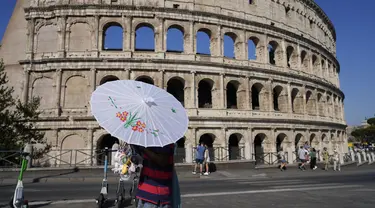 Seorang pria menjual payung dan kipas mini portabel di depan Colosseum saat suhu udara diperkirakan akan mencapai 39 derajat Celcius (102,20 Fahrenheit) di Roma, Italia, Sabtu (10/8/2024). (AP Photo/Gregorio Borgia)