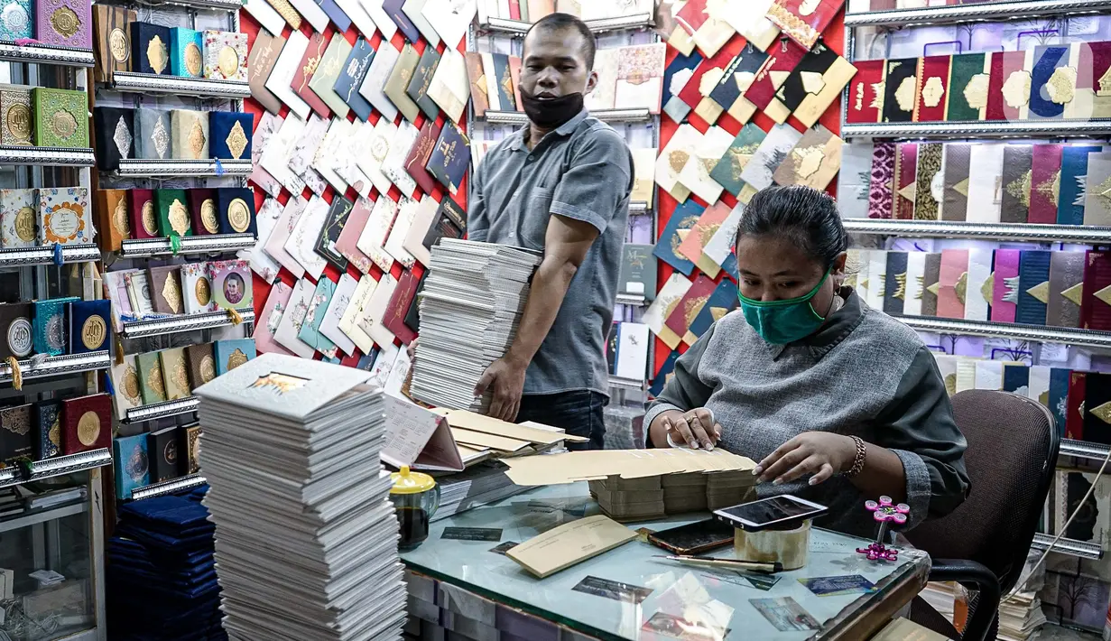 Aktivitas pedagang kertas undangan pernikahan di Pasar Tebet, Jakarta, Kamis (22/7/2020). Adanya larangan saat pandemi covid-19 untuk mengadakan acara yang bisa menimbulkan kerumunan, seperti pesta pernikahan, menyebabkan pendapatan usaha percetakan ini turun drastis. (Liputan6.com/Faizal Fanani)