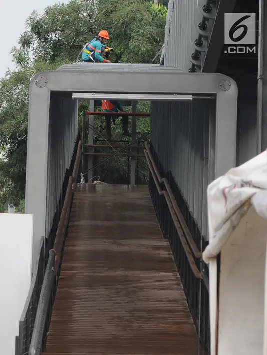 Petugas menyelesaikan proyek pembangunan jembatan penyeberangan orang (JPO) Bundaran Senayan di kawasan Sudirman, Jakarta, Sabtu (5/1). Revitalisasi tiga di kawasan Sudirman ditargetkan selesai pada pertengahan Januari 2019. (Liputan6.com/Herman Zakharia)