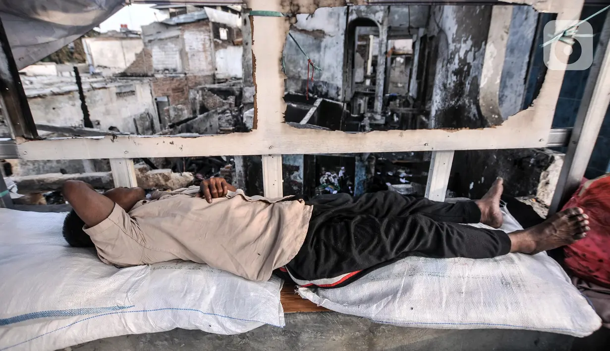 Warga terdampak tidur di kawasan RW 01 Pasar Gembrong, Kelurahan Cipinang Besar Utara, Kecamatan Jatinegara, Jakarta Timur, Rabu (11/5/2022). Berdasarkan data termutakhir, terdapat 185 rumah dengan 432 keluarga yang terdiri dari 691 jiwa terdampak kebakaran tersebut. (merdeka.com/Iqbal S. Nugroho)
