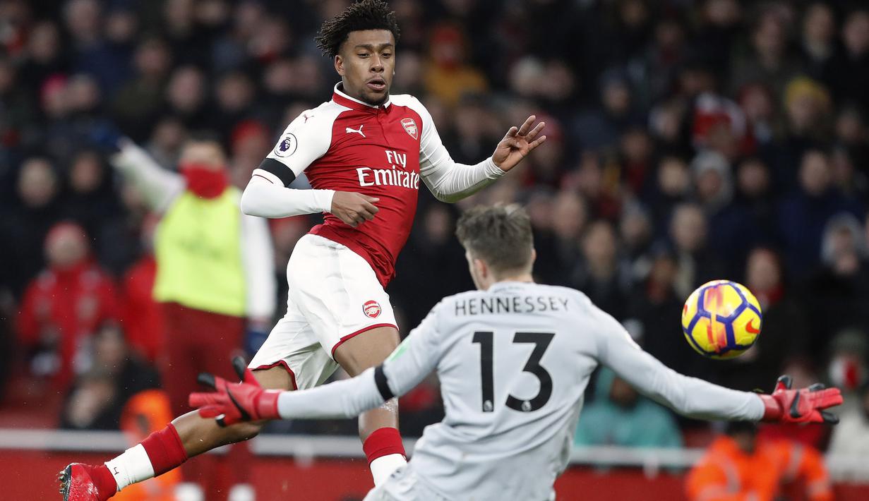 Pemain Arsenal, Alex Iwobi (kiri) mencetak gol setelah mengecoh kiper Crystal Palace, Wayne Hennessey pada lanjutan Premier League di Emirates stadium, London, (20/1/2018). Arsenal menang 4-1. (AP/Frank Augstein)