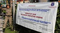 Personel Satpol PP wanita memasang spanduk penyegelan untuk menutup Hotel Alexis, Jakarta, Kamis (29/3). Ibu-ibu personel Satpol PP ini bertugas untuk memastikan tidak ada kegiatan usaha apapun di Hotel Alexis. (Liputan6.com/Immanuel Antonius)