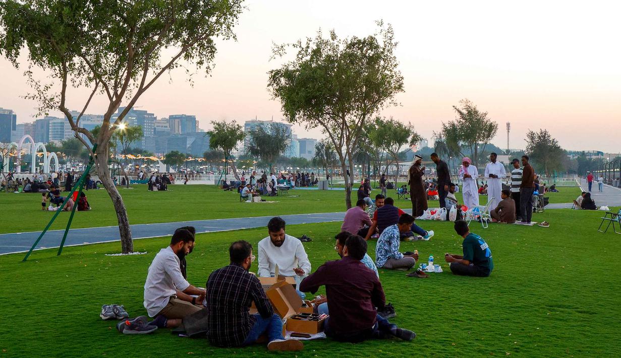 Tradisi ini tidak hanya sekadar penanda waktu, tetapi juga menjadi hiburan dan atraksi budaya yang dinantikan oleh anak-anak dan masyarakat setempat. Tampak dalam foto, orang-orang menyantap hidangan buka puasa (iftar) di Pelabuhan Doha Lama, Qatar selama bulan suci Ramadan 1447 Hijriah pada Kamis 24 Februari 2026. (Karim JAAFAR/AFP)