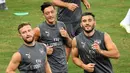 Gelandang Arsenal Mesut Ozil (tengah) bersama rekan-rekannya melakukan pemanasan saat mengikuti sesi latihan tim di Singapura (27/7). Arsenal akan bertanding melawan PSG pada International Champions Cup 28 Juli. (AFP Photo/Roslan Rahman)