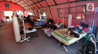 Pasien COVID-19 menjalani perawatan di dalam tenda darurat di RSUD Kota Bekasi, Jawa Barat, Jumat (25/06/2021). Puluhan pasien covid-19 saat ini dirawat dalam tenda darurat karena keterisian tempat tidur yang penuh akibat lonjakan kasus. (merdeka.com/Arie Basuki)