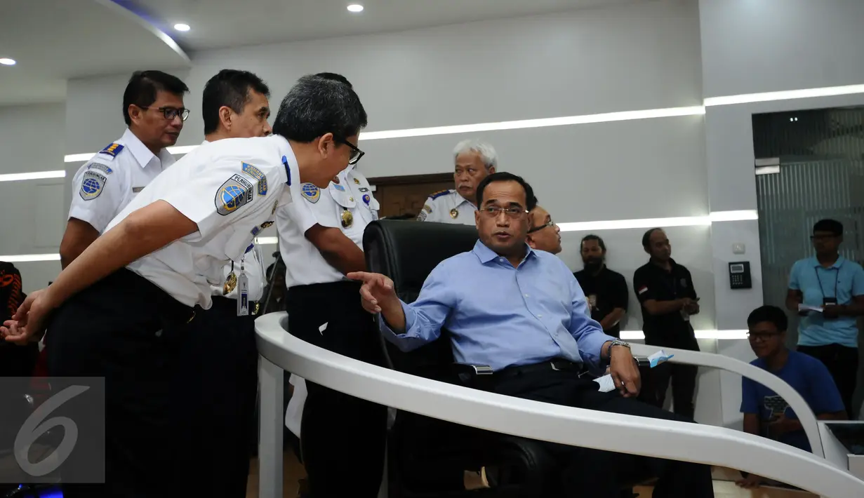 Menhub, Budi Karya Sumadi (kanan) berbincang dengan staffnya saat melakukan teleconference di Kemenhub, Jakarta, Minggu (25/12). Menhub Budi Karya memastikan angkutan pada Natal 2016 dan Tahun Baru 2017 berjalan lancar. (Liputan6.com/Helmi Fithriansyah)