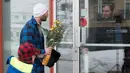 Seorang pria bersama anaknya membawa bunga untuk diberikan kepada jemaah di Masjid Quebec, Kanada, (2/2). Akibatnya penembakan enam orang tewas dan 12 orang lain menderita luka ringan. (Jacques Boissinot/The Canadian Press via AP)