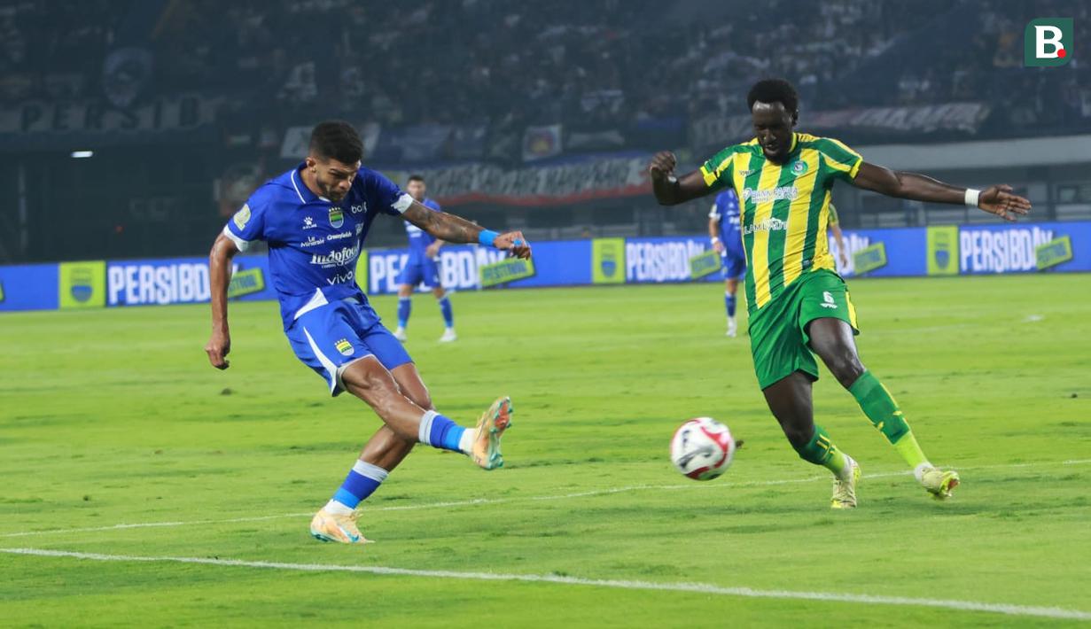 Pemain Persib Bandung, Berguinho (kiri) berusaha mencetak gol ke gawang PSBS Biak dalam laga pekan ke-18 BRI Super League 2025/2026 di Stadion GBLA, Kota Bandung, Minggu (25/1/2026) malam. (Bola.com/Erwin Snaz)
