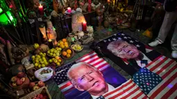 Gambar Presiden Donald Trump dan pesaingnya dari Demokrat Joe Biden, tergeletak di altar selama upacara, di dalam apartemen di Lima, Rabu (16/9/2020). Dukun Peru berkumpul untuk memprediksi siapa pemenang dari pemilihan presiden AS yang akan dihelat pada 3 November mendatang. (AP Photo/Rodrigo Abd)