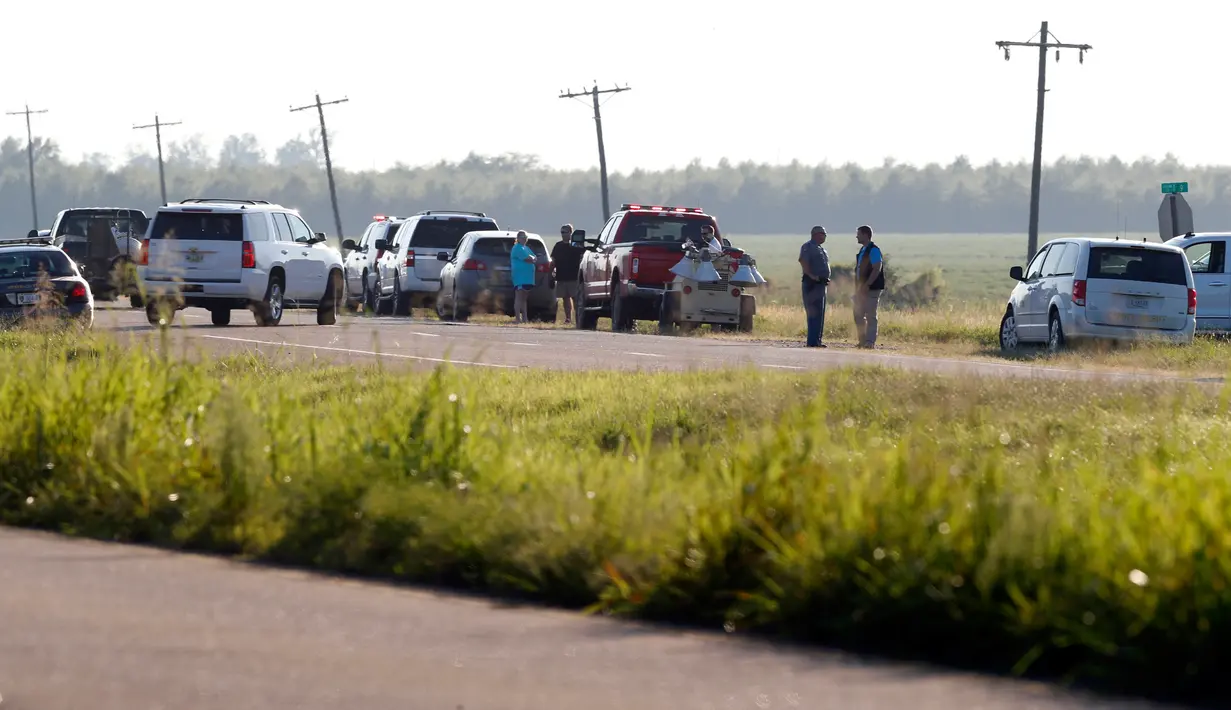 Petugas layanan darurat berdatangan ke lokasi jatuhnya sebuah pesawat milik korps marinir AS di jalur county Sunflower-Leflore, negara bagian Mississippi, Senin (10/7). Penyebab jatuhnya pesawat jenis KC-130 ini belum diketahui pasti. (AP Photo/Andy Lo)