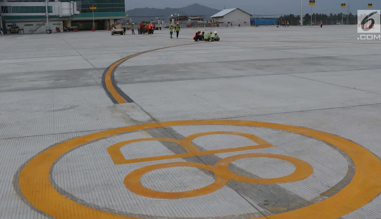 Pekerja menyelesaikan lajur pemandu pesawat di area apron Bandara Internasional Yogyakarta di Kab Kulon Progo, DI Yogyakarta, Selasa (23/4). Menurut rencana, khusus Bandara Internasional Yogyakarta ini akan mulai beroperasi pada 29 April mendatang. (Liputan6.com/Helmi Fithriansyah)