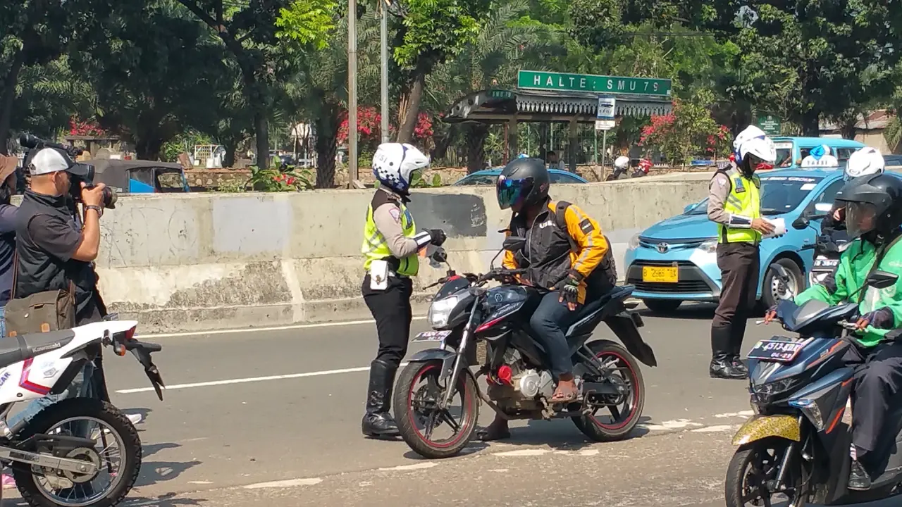 Polisi peringatkan ojek online yang mangkal di pinggir JLNT Casablanka (Liputan6.com/Nanda Perdana Putra)