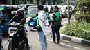 Massa aksi dari pengemudi ojek online membagikan pamflet sambil bergerak menuju Istana Negara, Jakarta, Senin (15/5). Dalam aksinya, pengemudi ojek online juga menuntut jaminan perlindungan atau asuransi kepada pengemudi. (Liputan6.com/Faizal Fanani)