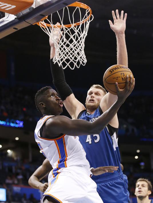 Pemain Oklahoma City Thunder, Victor Oladipo melakukan tembakan saat dihadang pemain Minnesota Timberwolves, Cole Aldrich #45 pada laga NBA basketball preseason game di Oklahoma City, Senin (17/10/2016) WIB. (AP/Sue Ogrocki)