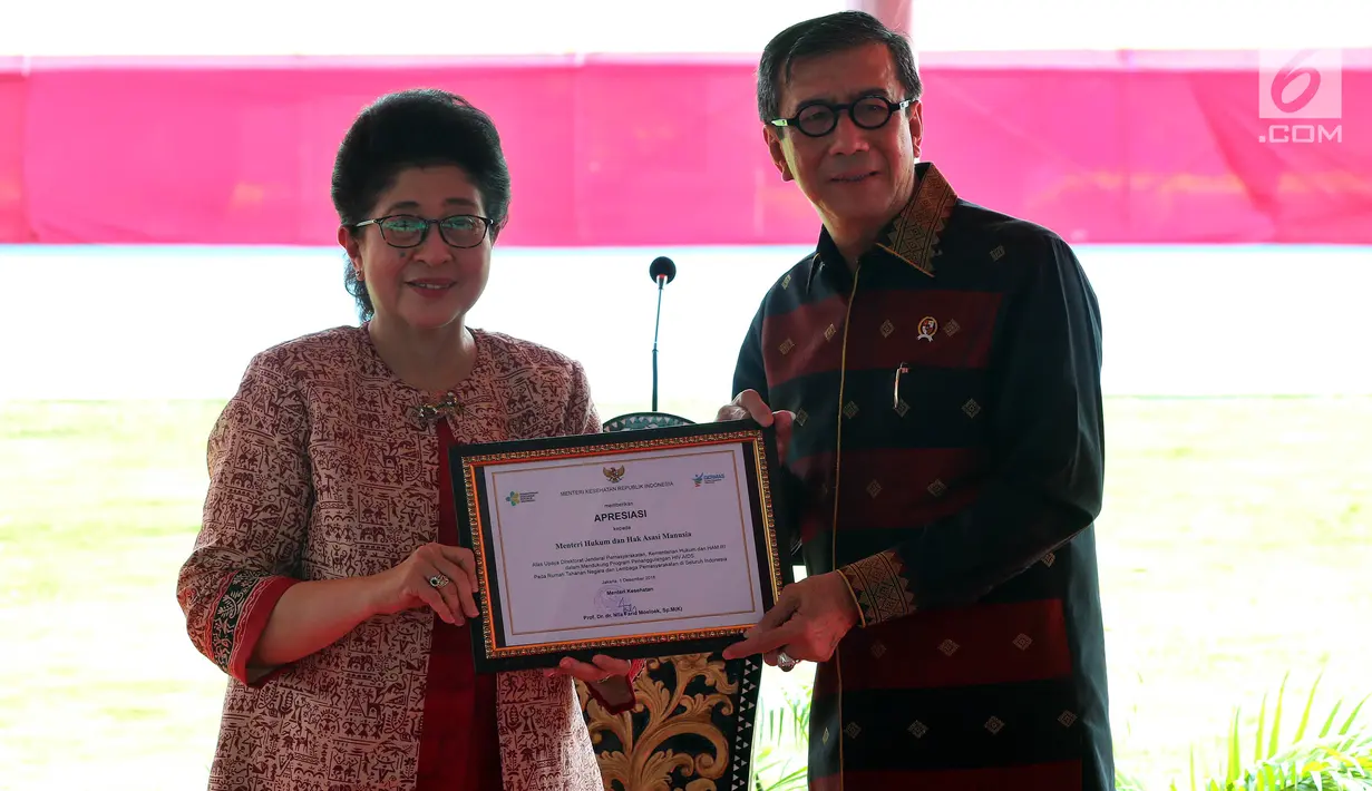 Menkes Nila F. Moeloek menyerahkan penghargaan kepada Menkumham Yasonna H. Laoly di Lapas Narkotika Kelas IIA Cipinang, Jatinegara, Jakarta Timur, Senin (17/12). (Liputan6.com/Johan Tallo)