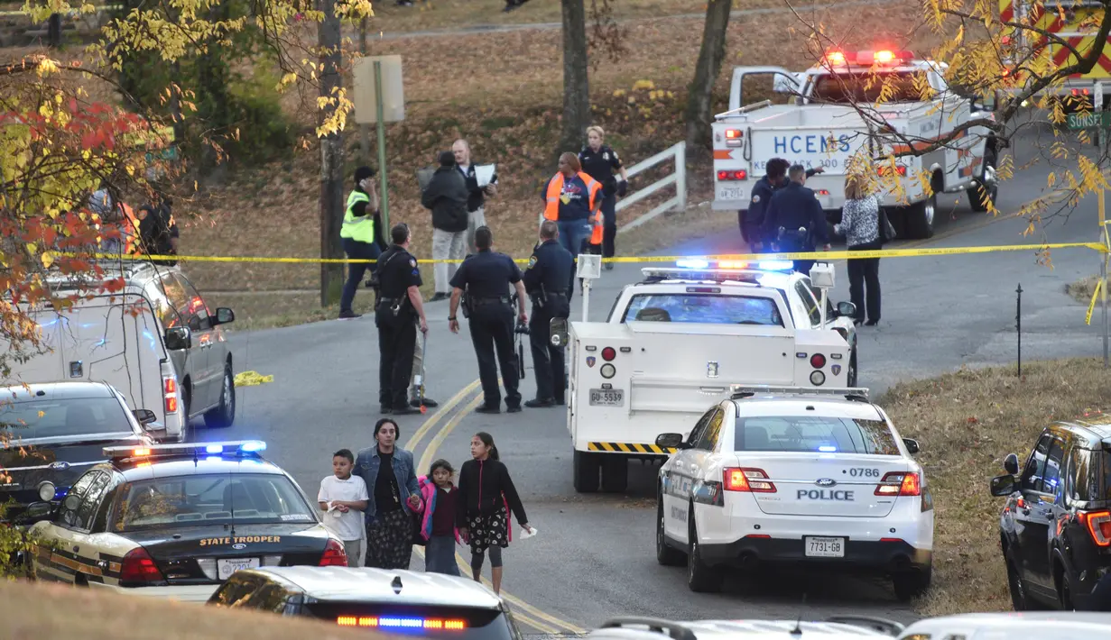 Seorang wanita membawa tiga orang anak menjauh dari lokasi kecelakaan bus sekolah di Chattanooga, Tennessee, Senin (21/11). Bus sekolah yang membawa sekitar 35 anak itu rusak setelah menabrak sebuah rumah. (Courtesy of Chattanooga Fire Dept/via REUTERS)