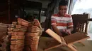 Pekerja menghaluskan kayu yang akan dibuat rekal Al Quran atau tatakan untuk Al Quran di kawasan Klender, Jakarta, Senin (5/6). Mayoritas pemesanan rekal Al Quran berasal dari masjid di kawasan Jakarta. (Liputan6.com/Angga Yuniar)