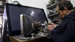 Seorang teknisi Tv saat memperbaiki Tv analog yang rusak, Mexico City, Meksiko, (16/12). Hal ini dalam upaya pergeseran teknologi yang dilakukan oleh pemerintah Meksiko. (REUTERS/Henry Romero)