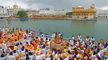 Umat Sikh membawa teks pokok agama Sikhisme, Palki Guru Granth Sahib selama prosesi keagamaan dari Gurudwara Ramsar ke Akal Takht Sahib di Kuil Emas, Amritsar, India, Rabu (19/8/2020). Acara ini untuk memperingati 416 tahun pelantikan Guru Granth Sahib. (NARINDER NANU/AFP)