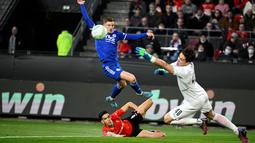Gelandang Leicester City Harvey Barnes (kiri) ditekel oleh bek Rennes Nayef Aguard pada leg kedua babak 16 besar Europa Conference League di Roazhon Park, Jumat (18/3/2022) dini hari WIB. Meski kalah dengan skor tipis 1-2, Leicester City tetap lolos ke perempat final. (DAMIEN MEYER/AFP)