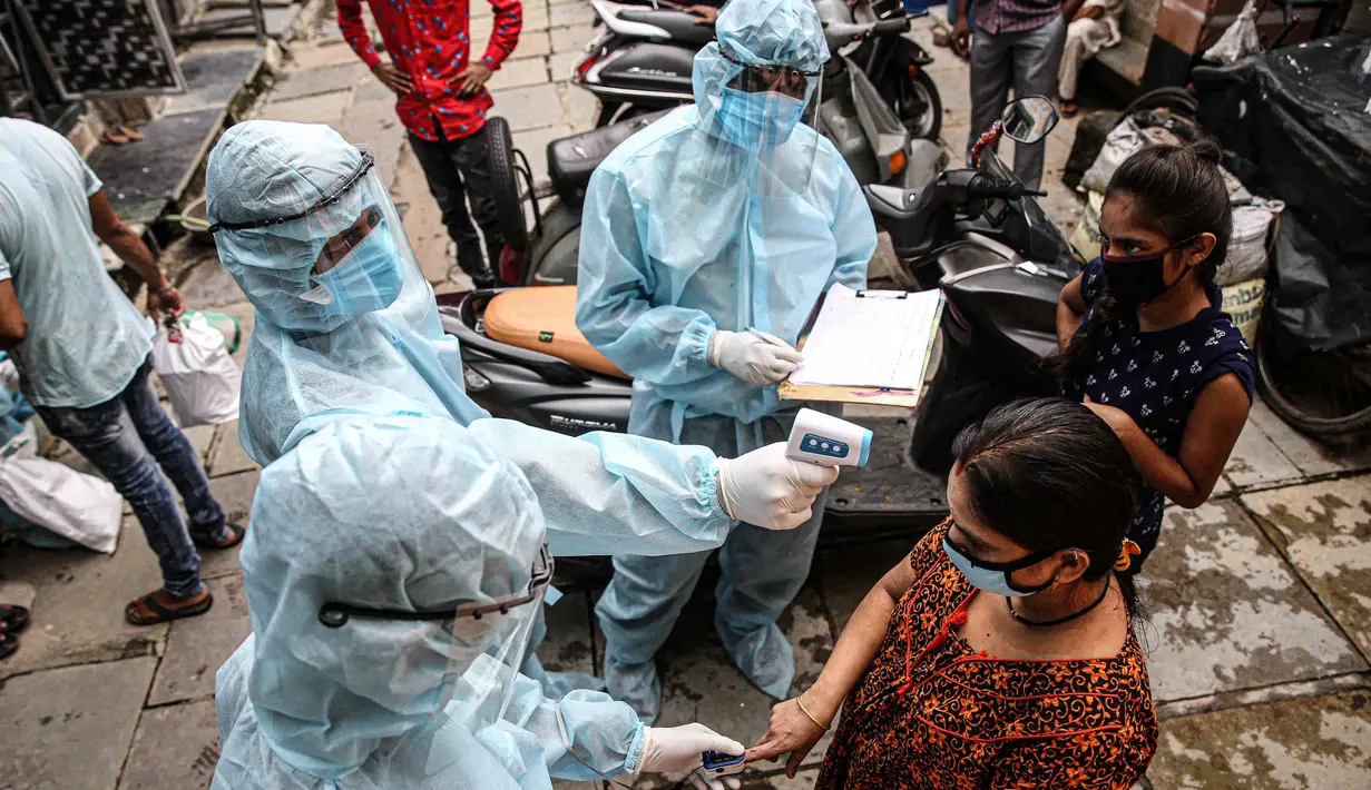 Petugas kesehatan India yang mengenakan alat pelindung diri melakukan pemeriksaan COVID-19 di kawasaan permukiman kumuh di tengah penyebaran wabah tersebut di Mumbai, India (17/6/2020). (Xinhua/Stringer)