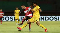 Diego Assis (Madura United) berduel melawan pemain Semen Padang di Stadion Gelora Madura, Pamekasan, Rabu (28/8/2019). (Bola.com/Aditya Wany)
