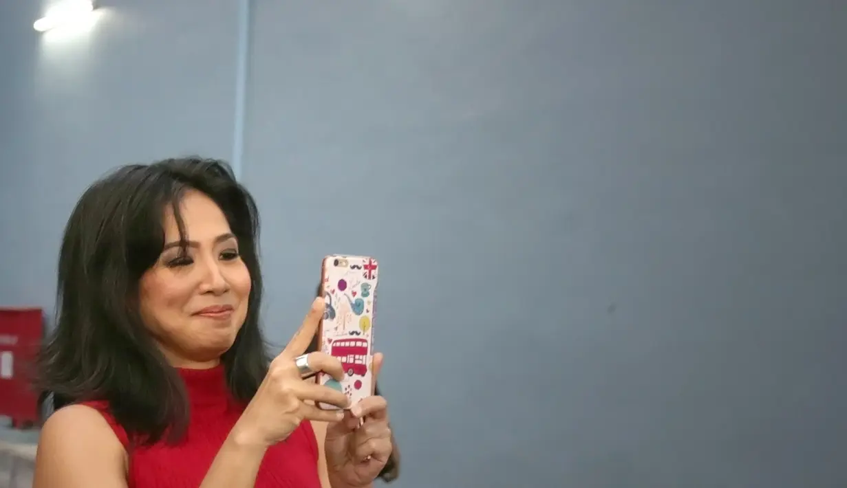 Sembari berjalan santai menuju mobilnya, ia hanya melempar senyum sembari memegang handphone. Bahkan ia menyempatkan untuk memotret para wartawan dengan handphonenya. (Bambang E. Ros/Bintang.com)