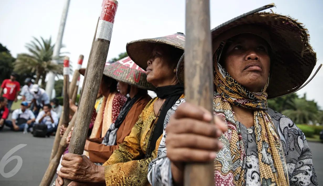 Sejumlah petani Pegunungan Kendeng menabuh lesung saat menggelar aksi di depan Istana Merdeka, Jakarta, Rabu (12/4). Mereka meminta Pemerintah untuk menghentikan pembangunan dan pabrik semen di Pegunungan Kendeng. (Liputan6.com/Faizal Fanani)