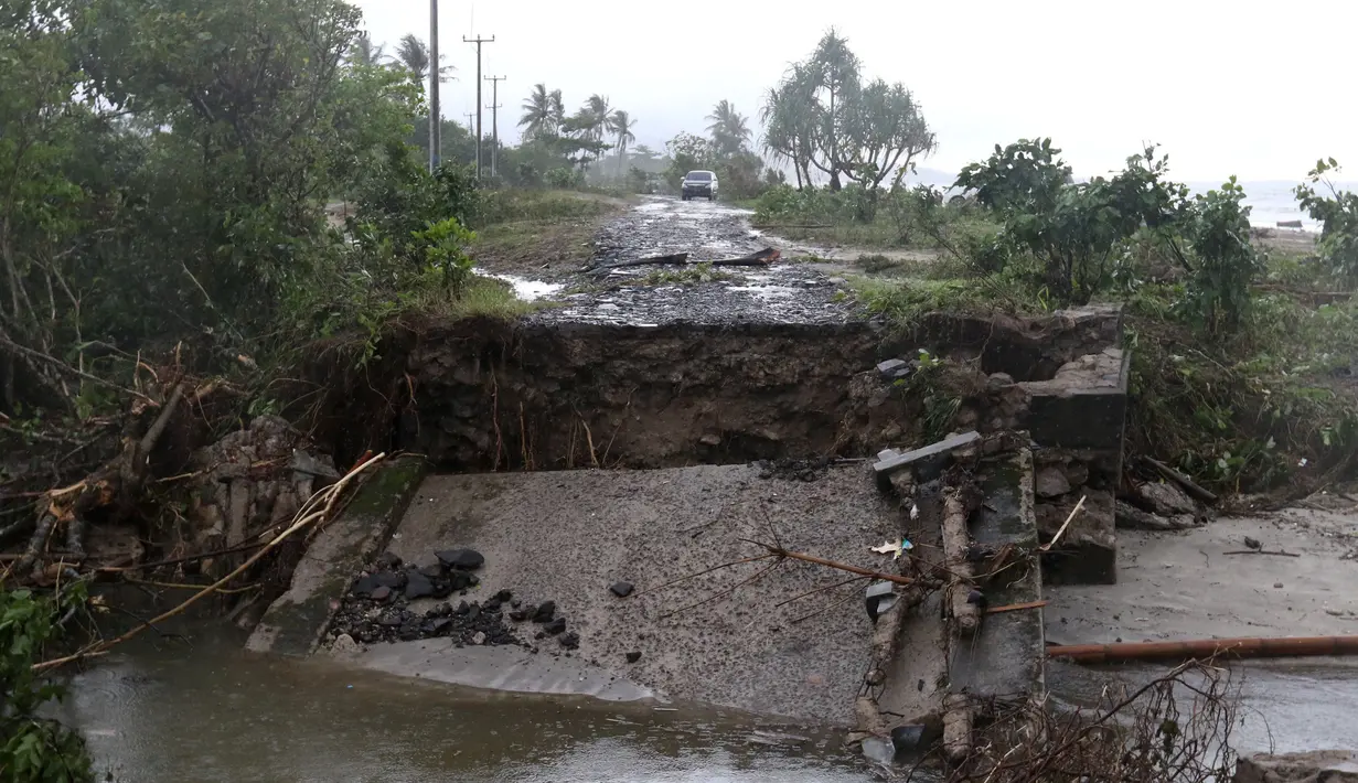 Jembatan penghubung ambruk diterjang gelombang Tsunami Selat Sunda di jalur alternatif Sumur, Banten, Senin (24/12). Sejumlah kendaraan terpaksa melintasi pantai karena jembatan tidak bisa dilewati. (Liputan6.com/Angga Yuniar)