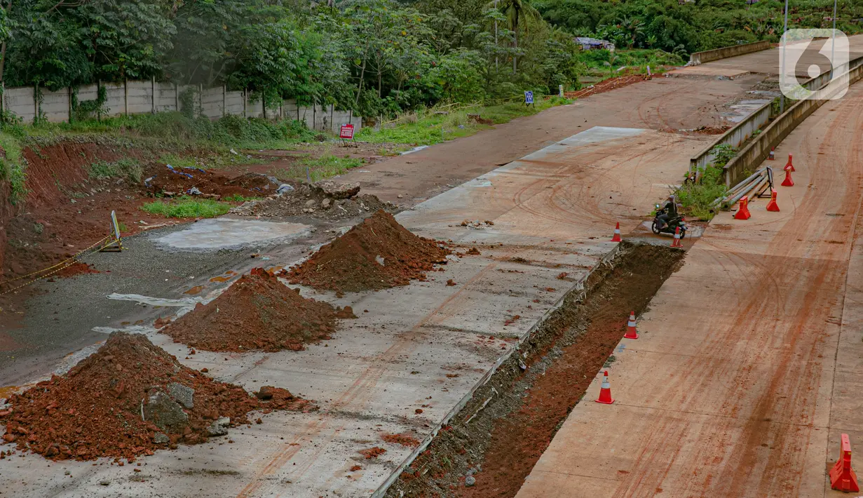 Pengendara motor terlihat melintas di proyek pembangunan jalan tol ruas Serpong - Cinere di Tangerang Selatan, Banten, Selasa (16/2/2021).  Konstruksi fisik jalan bebas hambatan berbayar sepanjang 14,19 kilometer tersebut akan tuntas pada April 2021 mendatang. (Liputan6.com/Faizal Fanani)