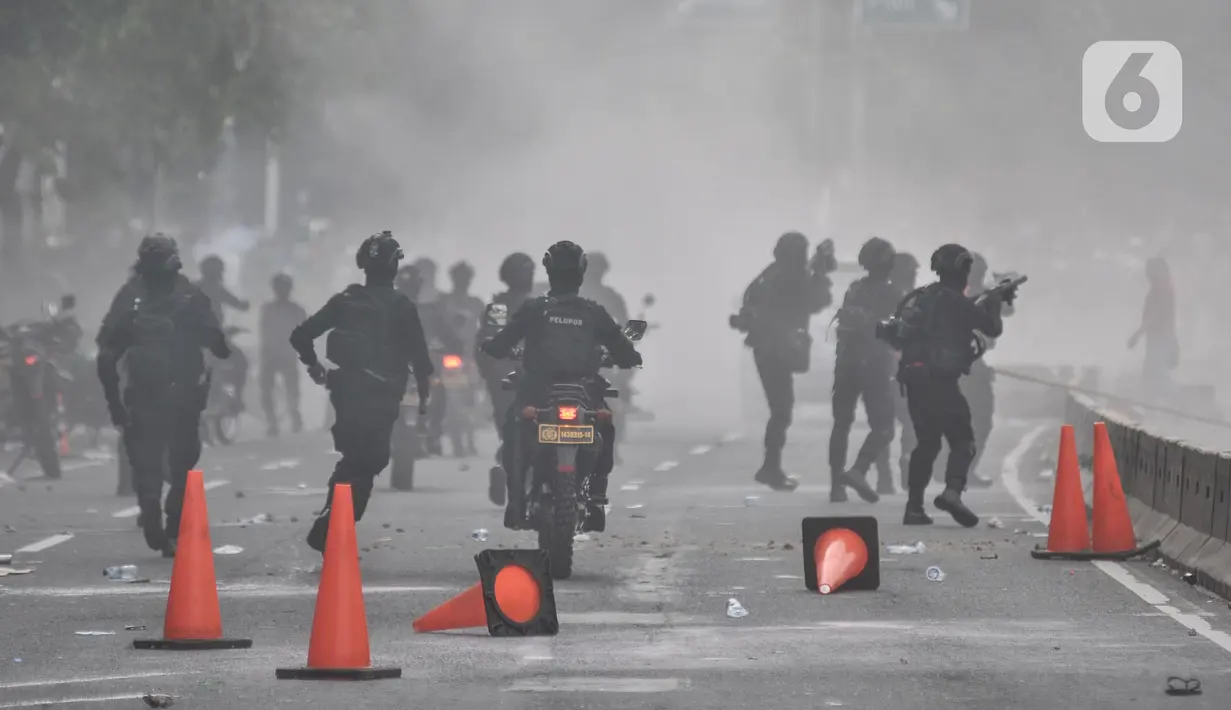 Petugas kepolisian menembakkan gas air mata saat berupaya membubarkan massa yang menggelar aksi di depan Gedung DPR RI, Jakarta, Senin (11/4/2022). Situasi mulai memanas akibat sejumlah pengunjuk rasa melempari petugas dengan berbagai benda. (merdeka.com/Iqbal S Nugroho)
