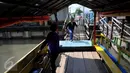 Warga tampak akan menaiki perahu untuk menyeberangi Kali Angke, Jakarta, Kamis (25/2). Sehari-hari pemilik perahu getek mendapat uang 60rb s/d 80 ribu. (Liputan6.com/Faisal R Syam)