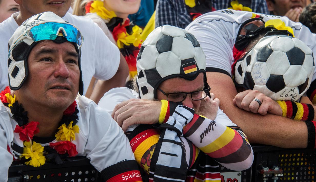 Suporter Jerman tampak kecewa usai ditaklukkan Korea Selatan pada Piala Dunia 2018 di Kazan Arena, Rusia, (27/6/2018). Jerman takluk 0-2 dari Korea Selatan. (AFP/AFP John Macdougall)
