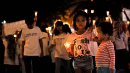 Seorang anak tampak ikut melakukan aksi damai dengan menyalakan lilin di Bundaran HI, Jakarta, Kamis (20/11/2014). (Liputan6.com/Faisal R Syam)