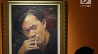 Pengunjung melintas di depan lukisan Chairil Anwar yang dipamerkan pada pameran seni rupa koleksi nasional #2 yang bertema Lini Transisi di Galeri Nasional, Jakarta, Selasa (13/8/2019). Pameran berlangsung hingga 31 Agustus mendatang. (Liputan6.com/Helmi Fithriansyah)