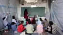 Data dari UNICEF pada November 2025 bahkan mencatat angka yang lebih tinggi, yaitu 97% sekolah mengalami kerusakan dalam berbagai tingkat. Tampak dalam foto, anak-anak pengungsi Palestina mengikuti belajar mengajar di dalam tenda di Sekolah Mada, kamp pengungsi Jabalia, Jalur Gaza Utara pada 13 April 2026. (Omar AL-QATTAA/AFP)