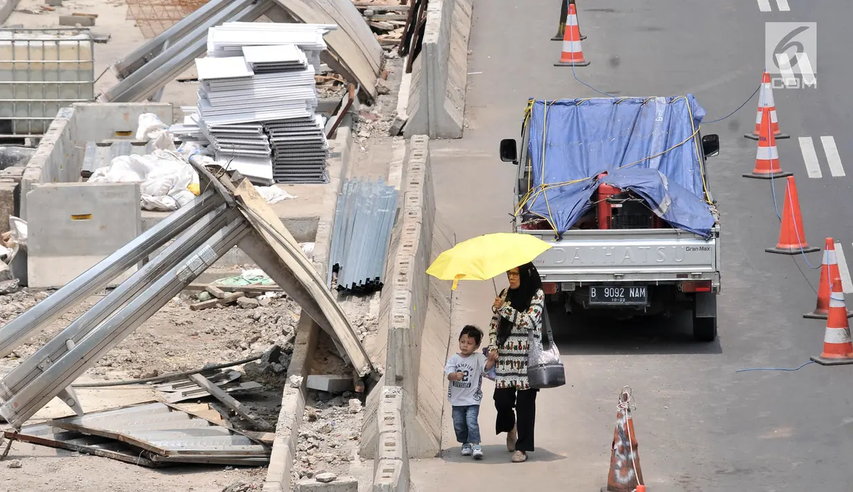 Pejalan kaki melintas di jalur khusus yang berada di bahu Jalan Jenderal Sudirman, Jakarta, Kamis (25/10). Proyek tersebut mempersempit jalur pejalan kaki dan menyebabkan kemacetan kendaraan. (Merdeka.com/Iqbal Nugroho)
