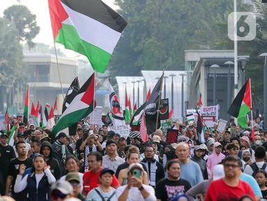 Sejumlah peserta aksi mengikuti aksi gerakan Global March to Gaza menuju kawasan Bundaran Hotel Indonesia, jalan MH Thamrin, Jakarta, Minggu (15/6/2025). (Liputan6.com/Herman Zakharia)