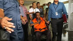 Tersangka dugaan korupsi proyek e-KTP, Sugiharto menggunakan kursi roda keluar dari Gedung KPK, Jakarta, Rabu (19/10). Setelah menjalani pemeriksaan sekitar 4 jam, Sugiharto keluar dengan memakai rompi tahanan berwarna oranye. (Liputan6.com/Helmi Afandi)