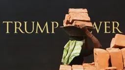 Seorang buruh wanita India mengangkat batu bata untuk pembangunan konstruksi Trump Tower atau Menara Trump di Kolkata, India (20/2). Trump Jr juga menjadi tuan rumah makan malam di Kolkata untuk menjamu para investor properti. (AFP/ Dibyangshu Sarkar)