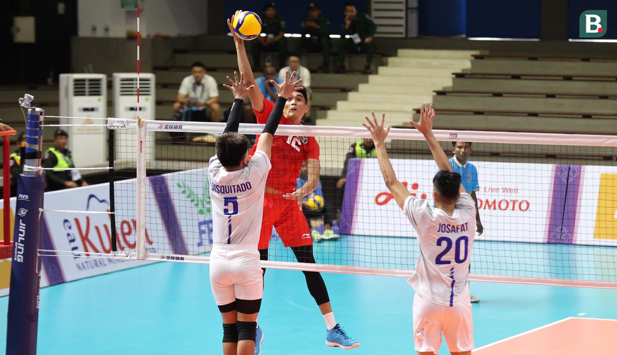 <p>Pemain tim bola voli putra Indonesia, Rivan Nurmulki melepaskan spike di depan dua pemain Filipina pada laga pertama Grup A cabor bola voli putra SEA Games 2023 di Olympic Complex Indoor Main Hall, Phnom Penh, Kamboja, Rabu (3/5/2023). Tim bola voli putra Indonesia menang 3-0 (25-18, 25-18, 25-23). (Bola.com/Abdul Aziz)</p>