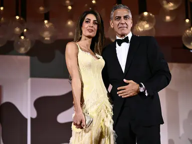 Aktor George Clooney dan istrinya Amal Clooney menghadiri pemutaran perdana film 'Wolfs' pada Festival Film Venice ke-81 di Venesia, Italia, pada Minggu (1/9/2024).  (Photo by Marco BERTORELLO / AFP)