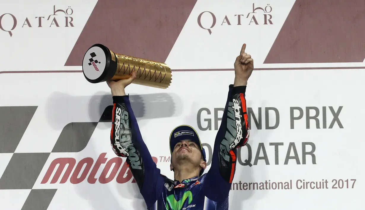 Pebalap Movistar Yamaha, Maverick Vinales, mengangkat pialanya usai memenangi MotoGP Qatar. Mantan pebalap Suzuki Ecstar tersebut kini memimpin klasemen MotoGP dengan perolehan 25 poin. (AFP/Karim Jaafar)