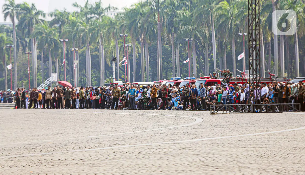 Masyarakat antusias menyaksikan HUT ke-78 TNI di Lapangan Silang Monas. Ada yang datang berkeluarga, ada yang sendirian, ada juga yang berkelompok bersama teman-teman. (Liputan6.com/Faizal Fanani)