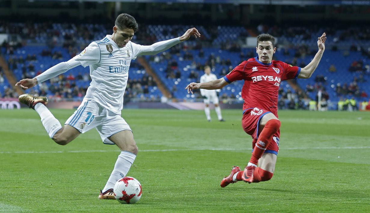 Pemain Real Madrid, Achraf Hakimi (kiri) mencoba melepaskan tembakan melewati pemain Numancia, Nacho Sanchez pada laga Copa Del Rey di Santiago Bernabeu stadium, Madrid, (10/01/2018). Real Madrid unggul agregat 5-2 atas Numancia. (AP/Francisco Seco)