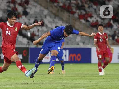 Pemain belakang timnas Indonesia U-20, Sulthan Zaky Pramana Putra (kiri) berusaha menahan tendangan bola dari Paripan Wongsa (Thailand U-20) saat International Friendly Match di di Stadion Utama Gelora Bung Karno (SUGBK), Jakarta Pusat, pada Jumat (26/1/2024). (Bola.com/M Iqbal Ichsan)